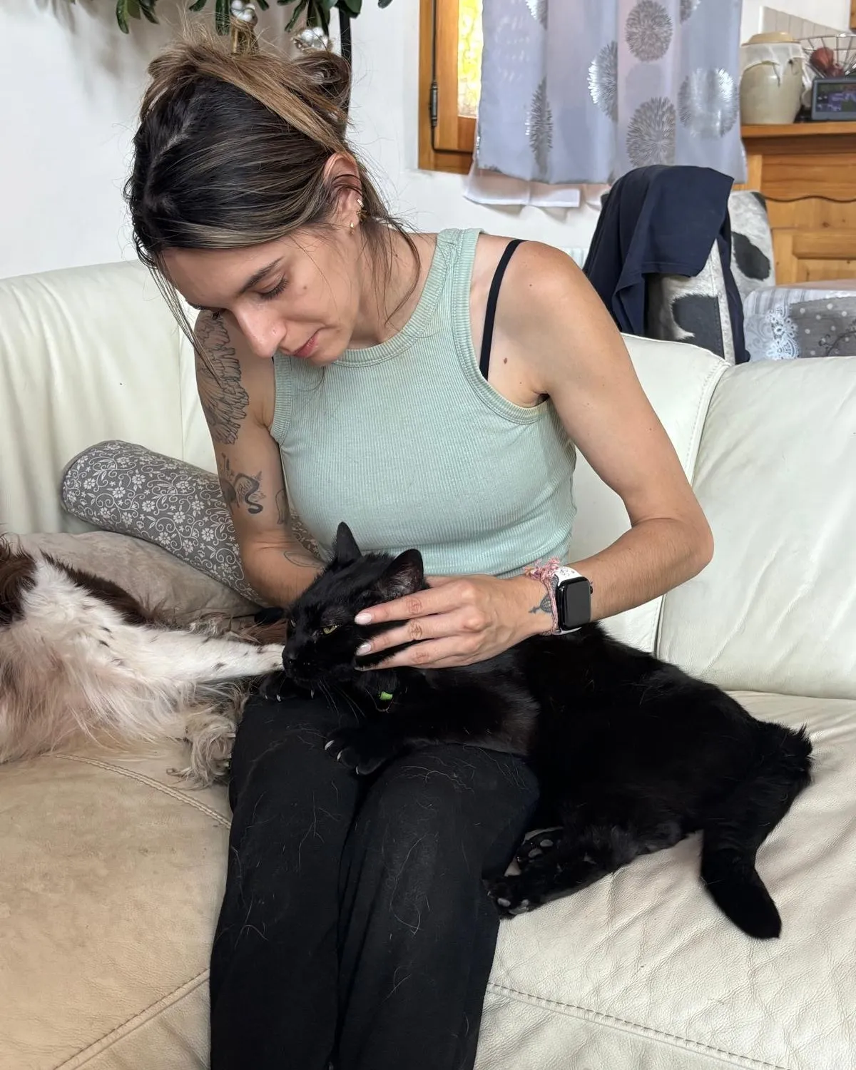 Isabelle Fourcade en séance avec un chat noir détendu, allongé sur ses genoux, à domicile